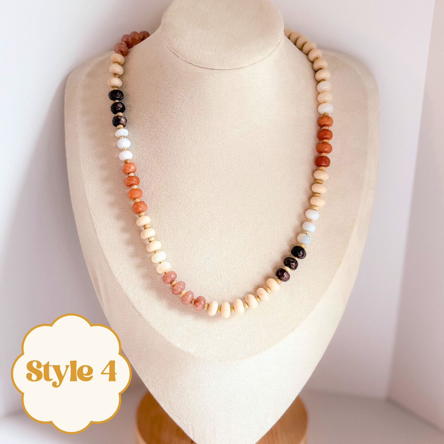 Necklace with multicolored neutral tone gemstone beads on a mannequin bust.