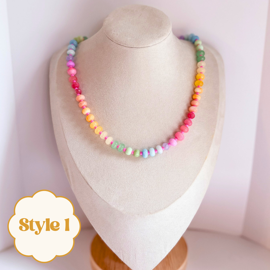 Colorful pastel rainbow beaded gemstone necklace on a mannequin bust.