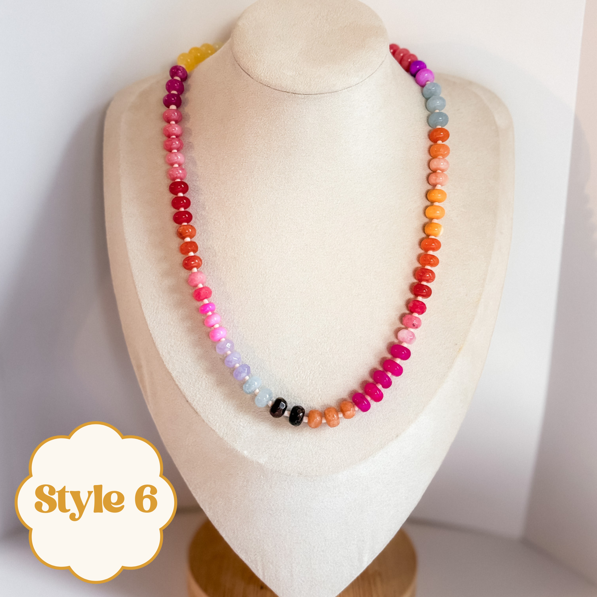 Vibrant colorful beaded gemstone necklace on a mannequin bust.